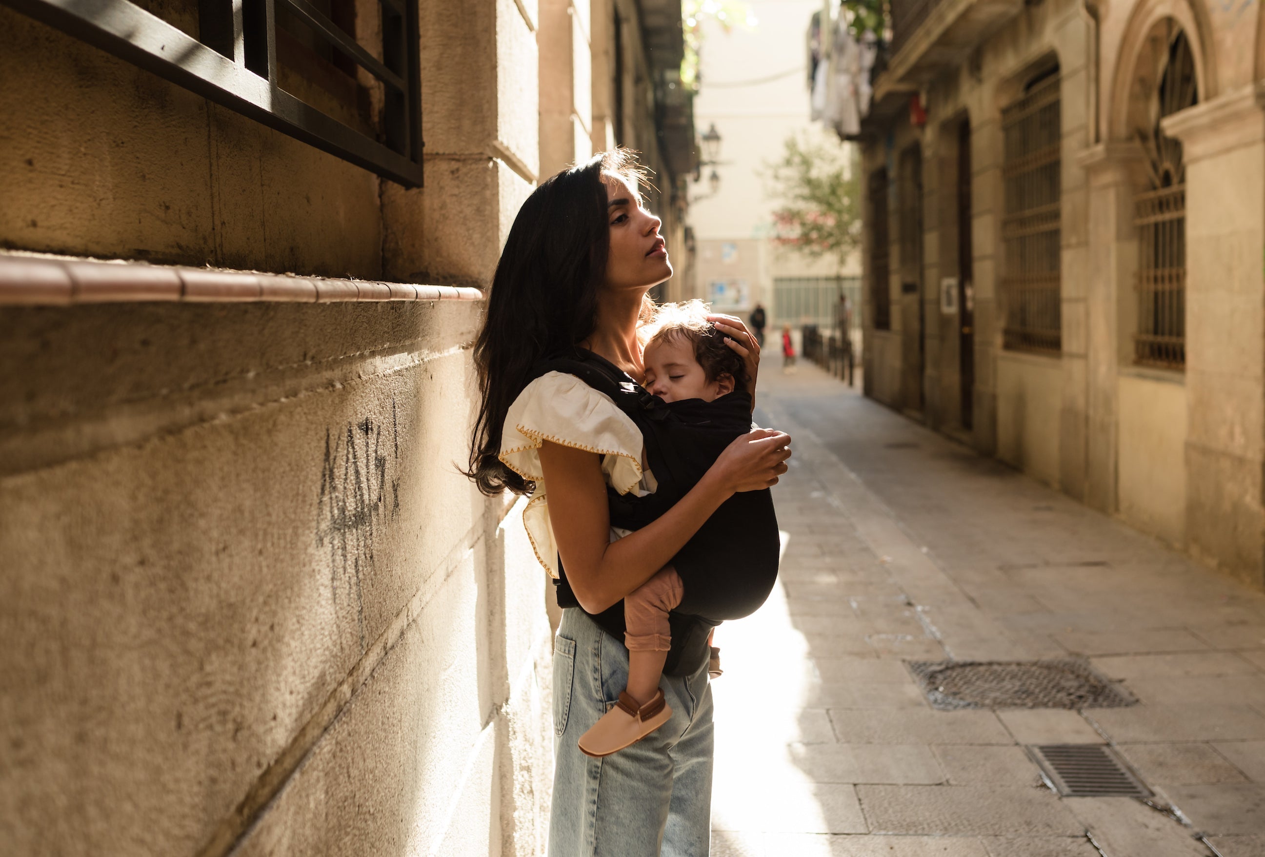 Calm and relaxed mom with her sleeping baby in the boba x black.