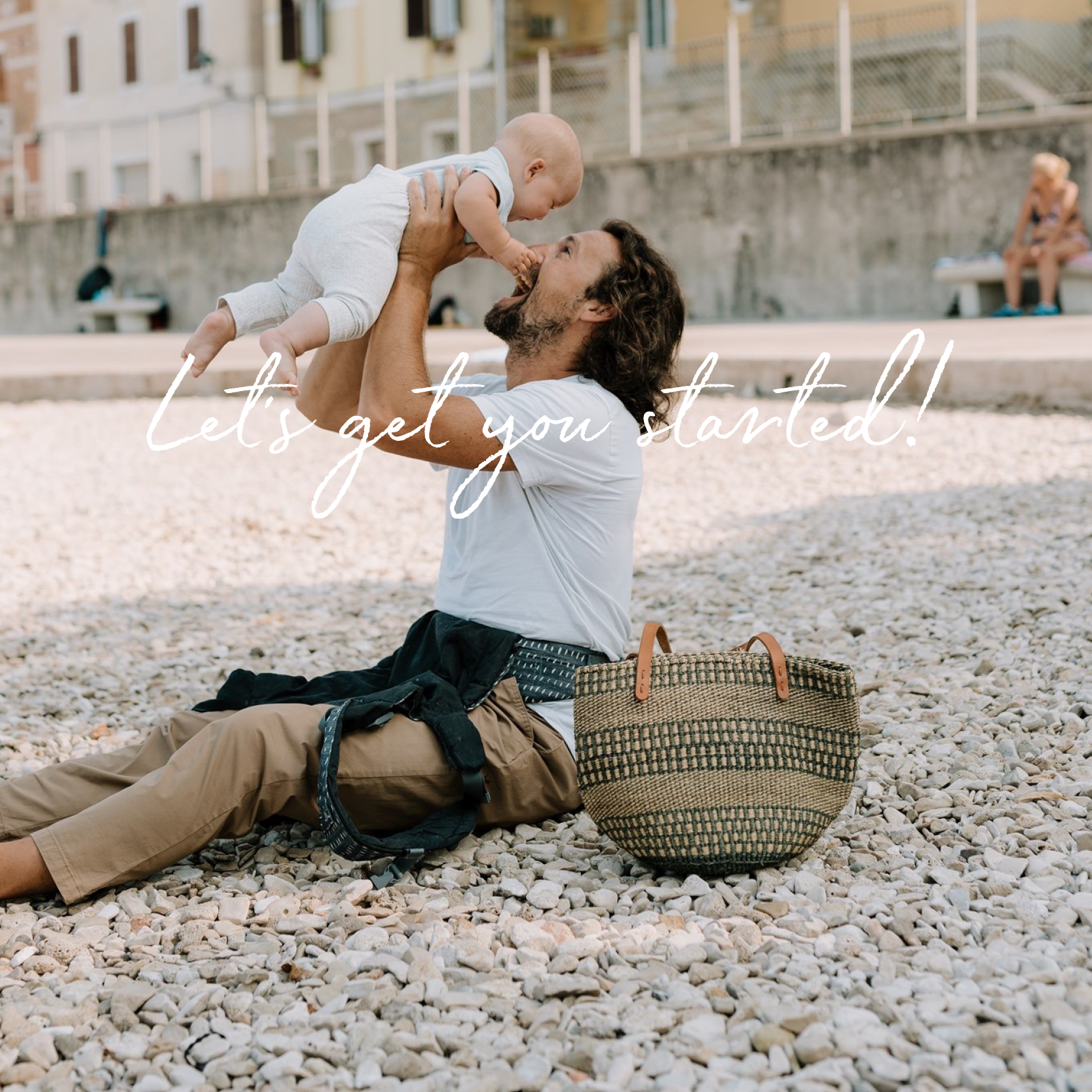 Confident dad on the beach with his daughter. He has a boba x baby carrier.